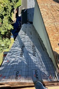 Roof Replacement15 - Integrity 1st Roofing Viewed from the roof edge, a pitched roof is under construction with GAF underlayment; OSB sheathing is exposed on the right, yard below on left side.
